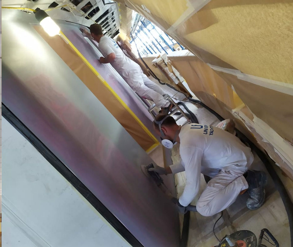 worker applying filler on superyacht surface